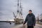 A man stands on the waterfront against the background of the ship on the Neva