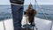 A man stands on a yacht and holds a newly caught sea bass