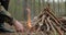 Man starts a fire in the forest using a lighter. Close-up of a man`s hand lighting a fire with a lighter. Lighting a fire in the