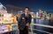 Man steward on ship board at night in miami, usa. Macho in suit jacket on city skyline. Water transport, transportation