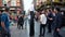 Man on stilts in the crowded streets of Covent Garden promoting local businesses