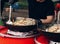 man stiring pasta with vegetables and seafood at street food festival. chef with gloves cooking traditional italian macaroni dis