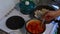 The man is stirring the chicken in a frying pan and tomatoes in a saucepan. Preparation of ingredients for tomato soup.