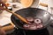 Man stirring onion slices in frying pan, closeup