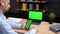 Man stock trader broker scrolling smartphone green display, laptop green screen