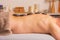 Man with stones on massage table at spa with body treatment. Person lying and relaxing during