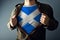 Man stretching jacket to reveal shirt with Scotland flag