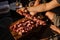 Man string meat pieces on the skewer and place them to the cutting board