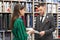 Man in striped suit choosing shirt, assistant proposing.