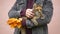 A man strokes a cat and holds autumn fallen maple leaves.