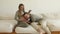 Man stroking and kissing pregnant wife\'s belly on sofa