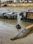 Man struggles to propel rowboat from houseboat on flooded Seine River, winter 2018, Paris, France