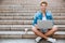 Man student using laptop while sitting on the staircase outdoors