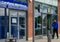 Man studies phone whilst passing phone shops