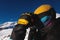 man in stylish sportswear and ski goggles. close up photo side view. a skier or snowboarder adjusts his mask before a