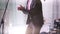 A man in a stylish suit dancing and clapping