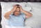 Man suffering from headache after sleep in bed