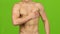 Man suffers from pain in breast muscle, green screen. Closeup