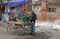 Man with sugar cane pressing machine mounted on a cart.