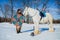 Man in suit of ancient warrior standing near the big white horse