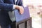 Man in suit puts folder with docs into briefcase