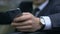 Man in suit scrolling smart phone and reading news, business process, close up