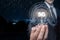 A man in a suit shows a light bulb with the inscription 5G on the background of the evening city