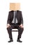 Man in suit sitting on a chair with a cardboard box on his head