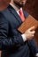 Man in suit stands with old book