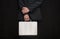 A man in a suit with a suitcase handcuffed on a black background, close-up, selective focus, dark tonality. Concept: secure delive