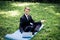 Man in a suit with tie. Business man relaxing in a park in the lotus position, he can`t relax in any way