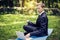 Man in a suit with tie. Business man relaxing in a park in the lotus position, he can`t relax in any way, typing text