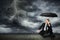 Man in a suit and umbrella seeks shelter from a storm