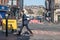 Man in suit walking across a road closed off with diversion and road closed signs.  Urban high street city setting