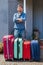 Man suitcase trip vacation home house luggage multi-colored pink blue family one ready wait jeans shorts baggage