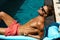 Man Summer Fashion. Male Model Tanning By Pool. Skin Tan