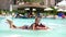 Man in sun glasses, father and daughter, kid girl, playing in the pool water, having fun together. Happy family relaxing