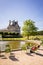 A man sunbathing on a metal lawn chair by a basin in the Tuileries garden in Paris with the Louvre palace in the background