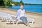 Man sunbathing sitting with laptop on beach