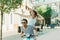 Man in sunglasses and happy young woman in straw hat riding moped and smiling