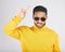 Man, sunglasses and horns sign in studio portrait, rock icon or hand gesture with clothes by white background. Young guy