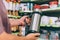 A man in a supermarket holds a thermos in his hands