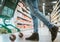 A man in a supermarket pushes a cart between the shelves