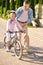 A man supporting a girl while she riding a bike