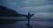 A man with a surfboard on the seashore