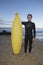 Man With Surfboard Standing On Beach