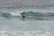 Man surfer glides on a surfboard on a wave