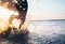 Man surfer run in ocean with surfboard. Closeup image water splashes and legs, sunset light