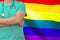 Man surgeon or doctor with stethoscope on the background of the LGBT gay flag. Health care, surgery and medical concept in LGBT