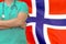 Man surgeon or doctor with stethoscope on the background of the Norway flag. Health care, surgery and medical concept in Norway